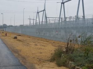 A high security fence surrounding large industrial fixtures