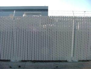 A chain link fence with white slats woven throughout it