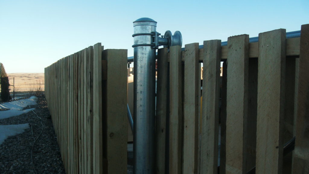 Cantilever gate support post with cantilever roller attached to cantilever gate with wood pickets