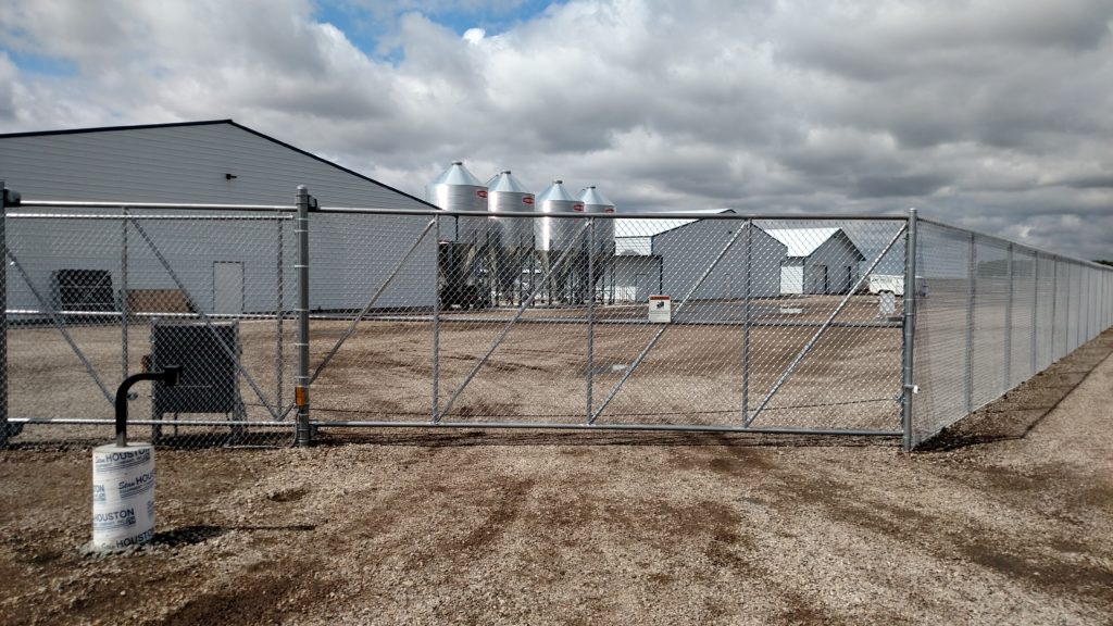 Steel cantilever chain link gate with keypad entry and sliding gate operator