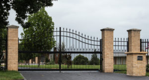 Arched decorative drive gate with pickets and finials