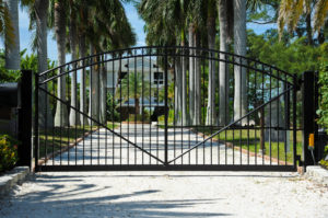 Commercial single swing Gate Protecting the Entrance to a Palm Tree Lined Driveway